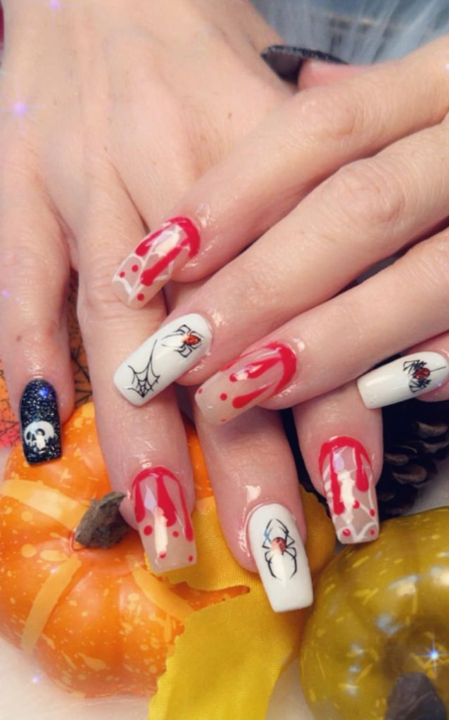 Image of Halloween-themed painted nails with spiders, spider webs, blood dripping, and a skull