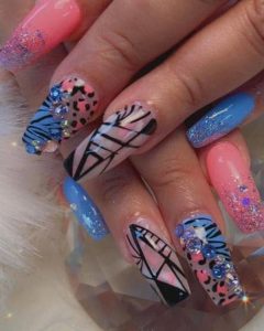An image of nails with colorful leopard print with rhinestones and geometric designs.