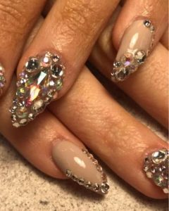 An image of nails featuring full coverage rhinestones in gold.