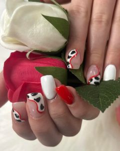 An image of red and white nails with cow print patterns.